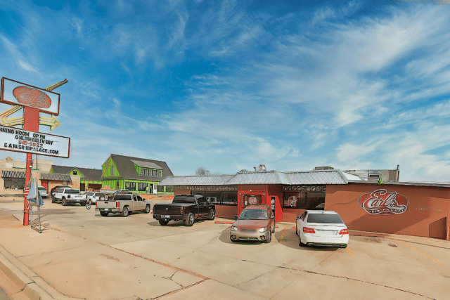 A restaurant at Earl's Rib Palace with cars parked in the parking lot.