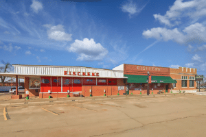 A parking lot with a red building near Eischen's.