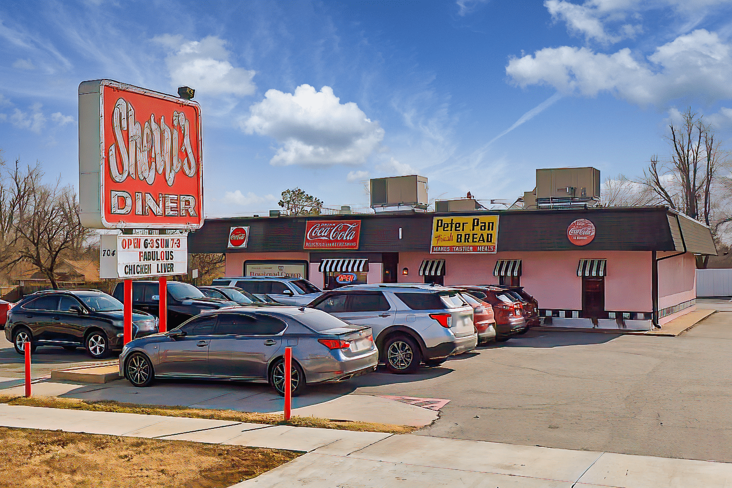 a parking lot with cars parked in front of Sherri's Diner.