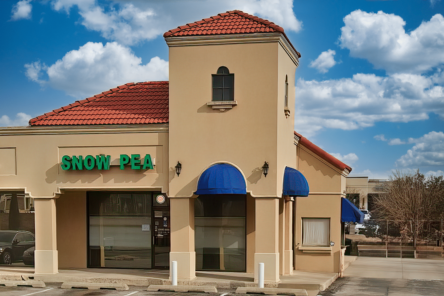 The Snow Pea Restaurant building with a blue awning.