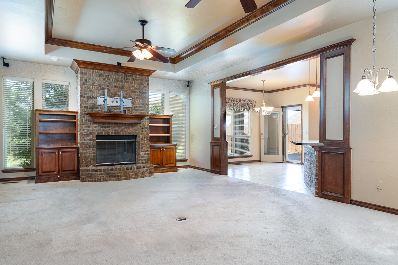 A living room with a fireplace and a ceiling fan.