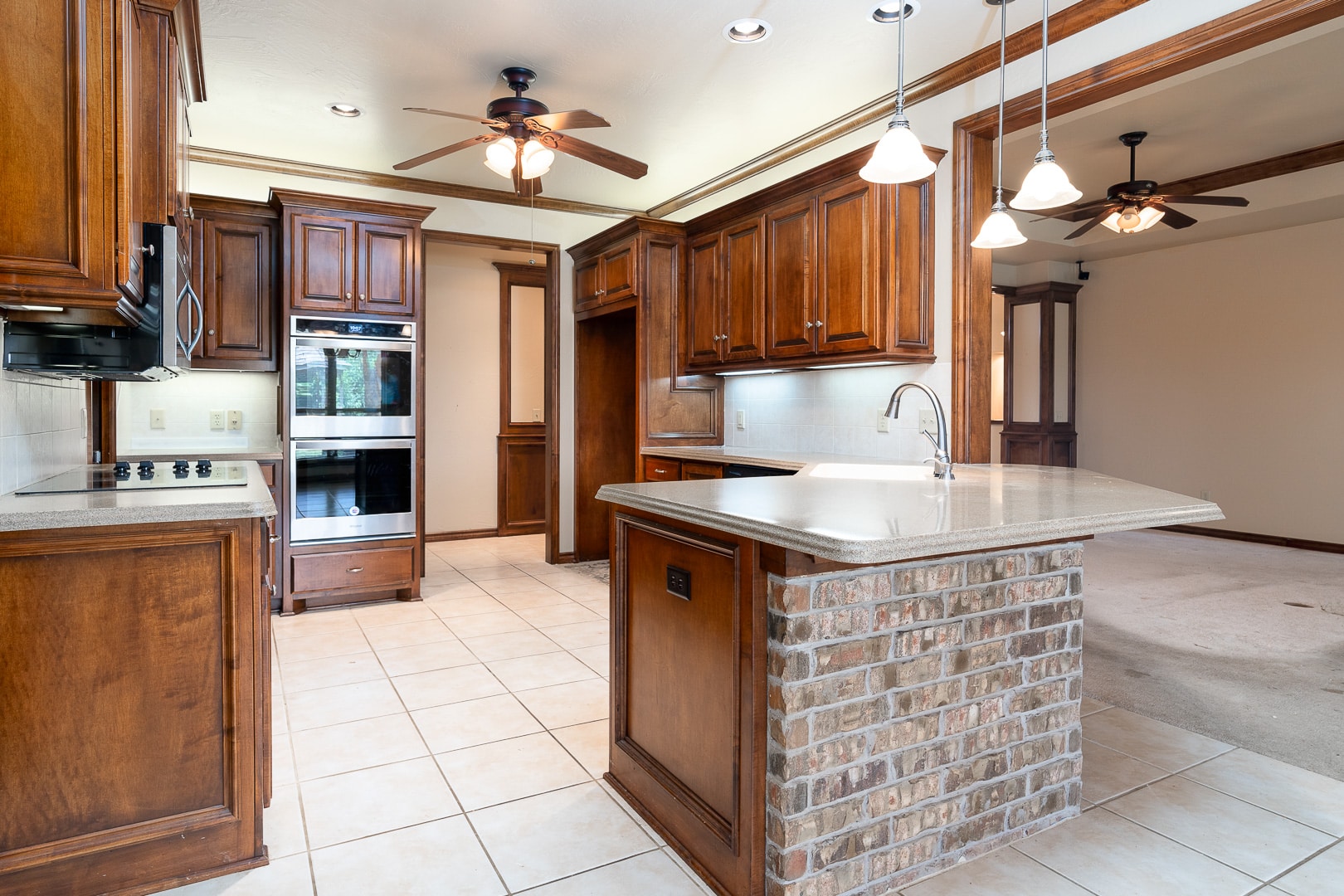 A kitchen with wood cabinets and a ceiling fan.