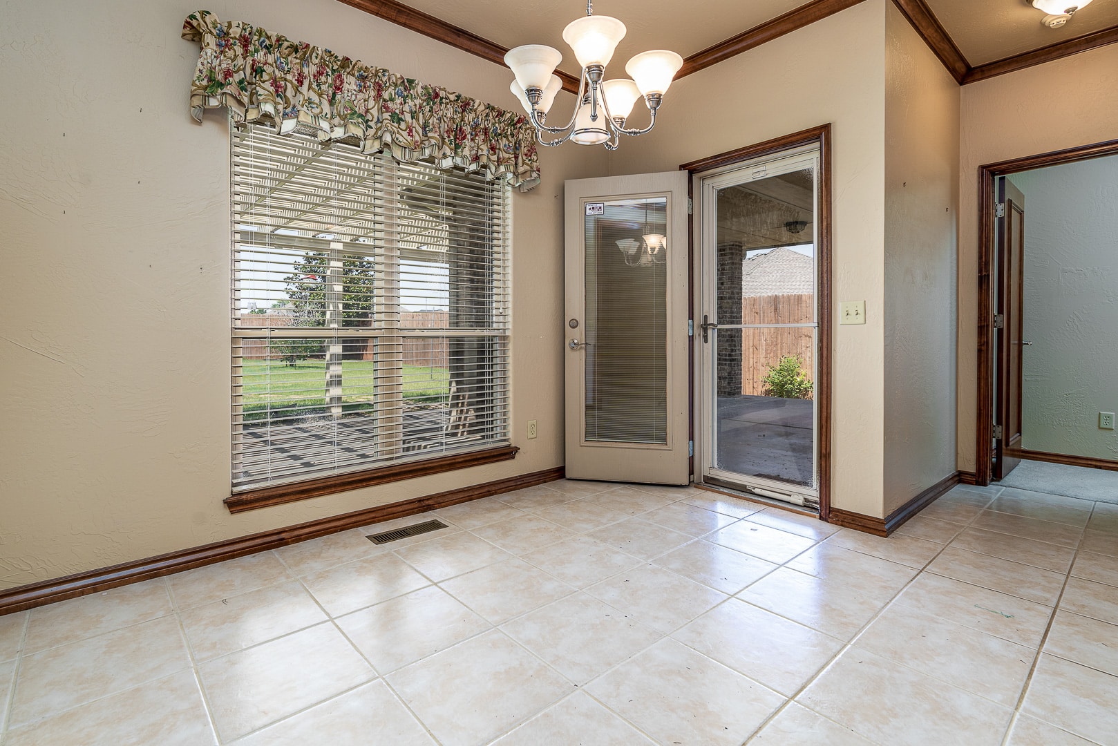 A room with a sliding glass door and tiled floor.