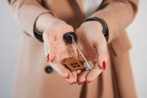 A woman holding house keys, symbolizing the end of the closing process for sellers.
