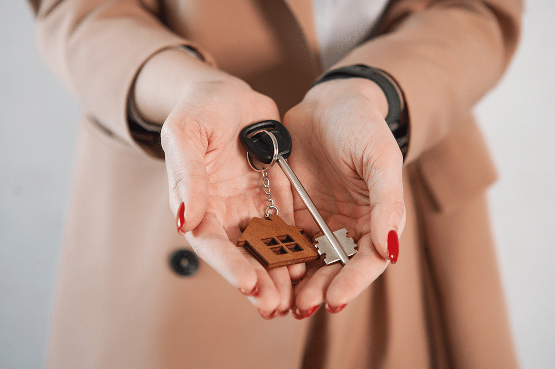 A woman holding house keys, symbolizing the end of the closing process for sellers.