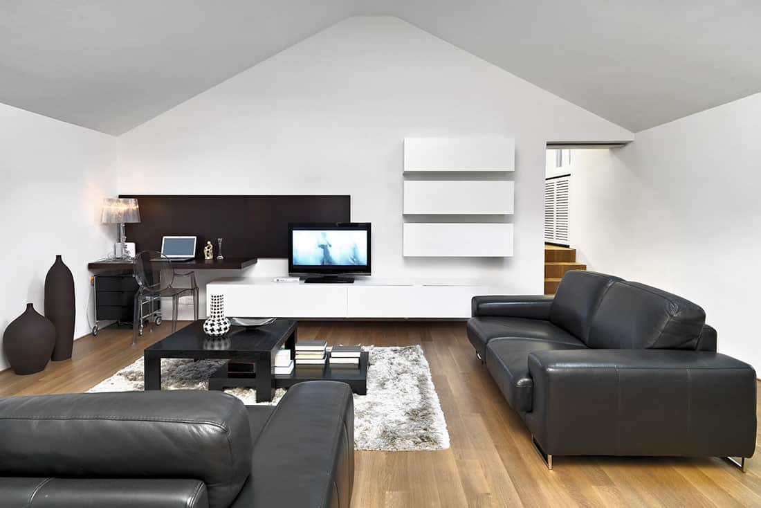 A black and white attic living room with a tv, perfect for showing DIY staging tips for attics.