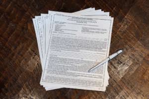 The Oklahoma real estate purchase agreement on a wood table with pen.