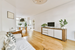 A small living room with white walls and wooden floors using visual tricks for small space staging.