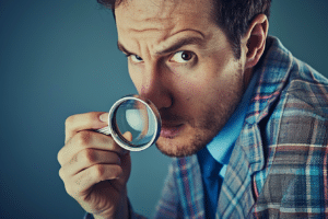 An appraiser carefully examining details through a magnifying glass amidst appraisal disputes.