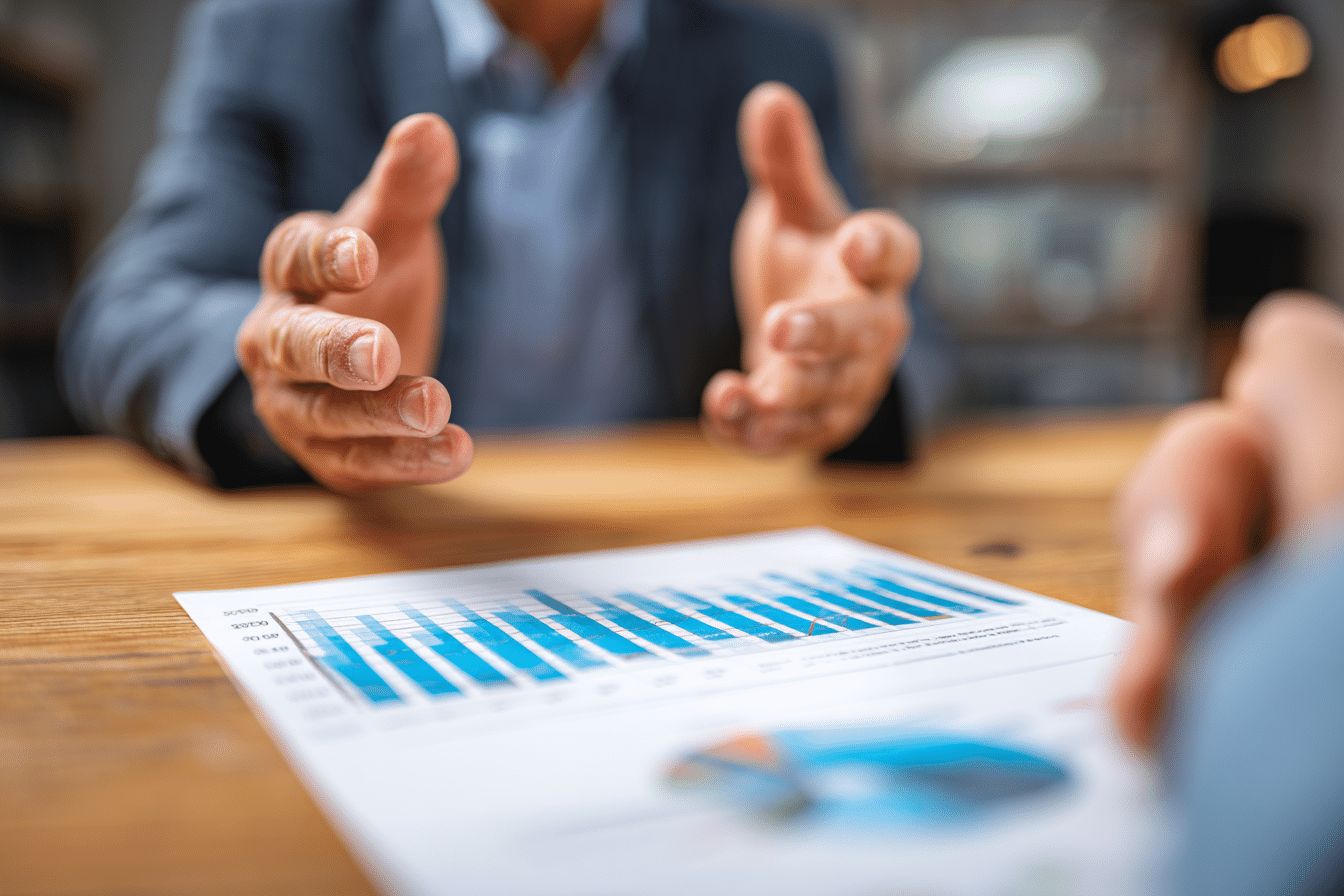 A person in a suit gestures with their hands while discussing the effect of mortgage interest rates.